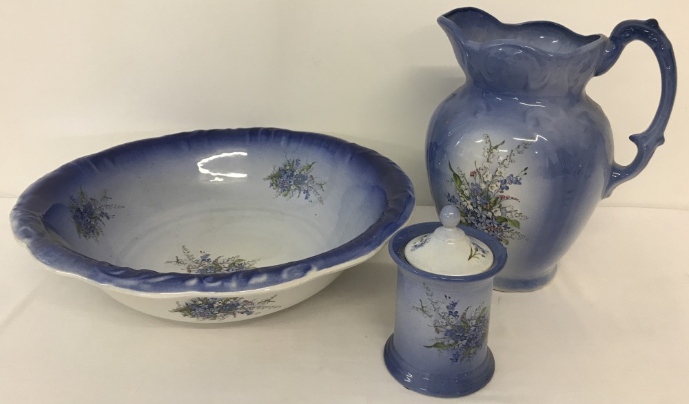 A vintage 3 piece ceramic bathroom set in blue with floral spray decoration.