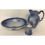 A vintage 3 piece ceramic bathroom set in blue with floral spray decoration.