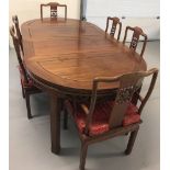 A large solid wood Oriental carved draw leaf dining table and 6 chairs.