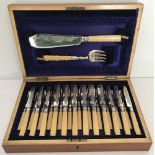 An Edwardian wooden cased cutlery set of fish and fruit knives & forks with servers.