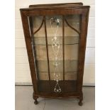 A small vintage glass display cabinet with glass door and side panels on small cabriole legs.