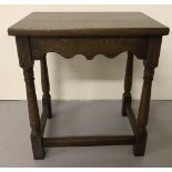 A vintage wooden side table with turned legs and scalloped detail.