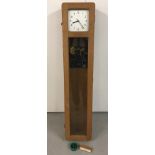 A wall mounted oak cased, glass fronted Master clock by Synchronome, London. Made in England.