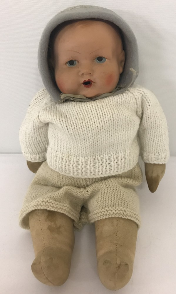 A vintage soft bodied composite head baby doll. With painted eyes lips and cheeks. Open mouth.