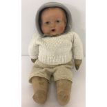 A vintage soft bodied composite head baby doll. With painted eyes lips and cheeks. Open mouth.
