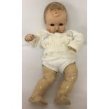 A soft body vintage composition baby doll with closing eyes, open mouth and two top teeth.