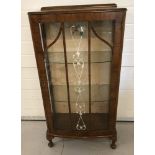 A small vintage glass display cabinet with glass door and side panels on small cabriole legs.