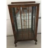 A small vintage glass door display cabinet with interior glass shelves.