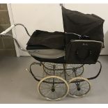 A vintage Silver Cross dolls pram in brown and cream colourway.