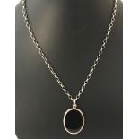 An oval silver pendant set with black onyx on a 22 inch silver belcher chain.