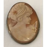 A large cameo brooch with pendant attachment set in white metal.