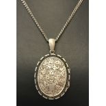 A Victorian white metal locket with floral decoration to front and back.