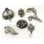 A collection of 7 silver and costume jewellery brooches.