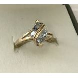 A ladies 9ct gold pale blue topaz set dress ring with gold twist design over the stone.