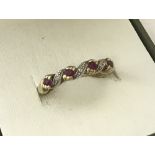 A 9ct ruby and diamond half eternity ring with twisted detail.