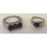 A ladies silver dress ring set with central purple stone.