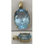 A 9ct gold pendant set with a large oval blue topaz stone.