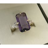 An Art Deco style ladies 9ct gold dress ring set with a large emerald cut amethyst.