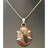 A 925 silver set Red Copper Onyx pendant on a 24" silver snake chain.
