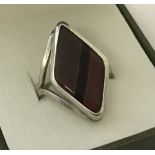 A modern design silver ring in a diamond shape set with tigers eye stone.