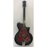 A 1950's red and black wooden cased hollow body electric guitar with f holes, possibly Framus.