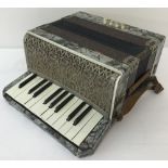 A vintage German Ceka Superior accordion with pearlised veneer and leather strap.