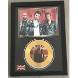 A photograph of the Band Muse with facsimile signatures and a gold presentation disc.