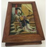 A wooden jewellery box with painted glass panel top depicting an oriental lady reading.