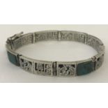 An Aztec design white metal eight panel bracelet set with malachite.