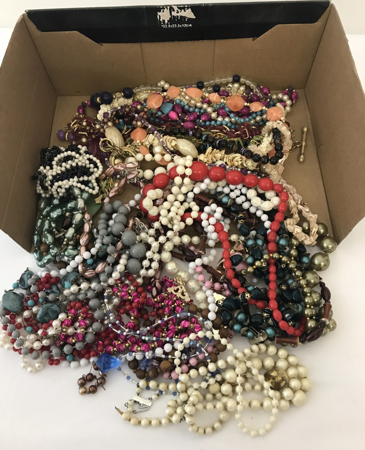 A box of vintage plastic and wooden bead necklaces.