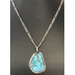 A turquoise and silver pendant on a 18 inch Figaro chain.