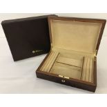 A boxed red Birdseye maple jewellery box by Walwood with a key.