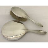 An Art Deco silver backed hand mirror together with matching hairbrush.