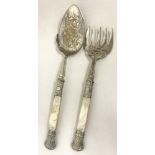 A 5 prong pearl handled fish serving fork, together with a matching serving spoon.