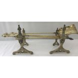 A pair of Victorian brass decorative fire dogs together with a set of fire irons.
