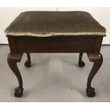 A vintage mahogany piano stool with cabriole style legs and ball and claw feet.