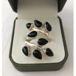 A modern leaf design ring set with 7 teardrop cut black onyx stones.
