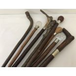 A collection of 8 vintage walking sticks to include wooden and horn handled examples.