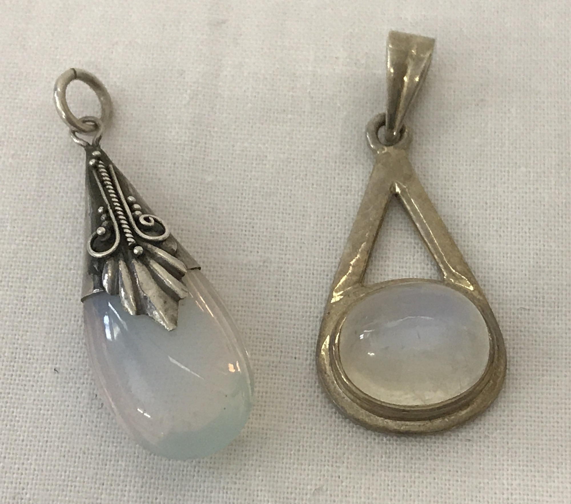 2 modern design drop pendants set with moonstones. One marked 925.