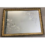 A large gilt framed over mantle mirror with bird and floral decoration to corners of the mirror.