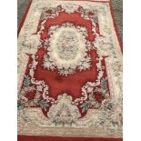 A large floral wool rug with fringed ends.