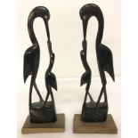 A pair of Indian carved horn figurines of storks on wooden plinths.