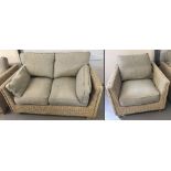 A modern rattan framed 2 seater settee with neutral coloured seat cushions.