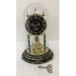 A vintage Kundo glass domed anniversary torsion ball pendulum clock.