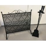 A black wrought iron fire screen and companion set.