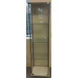 A modern slim line tall glass display cabinet with 3 interior shelves.