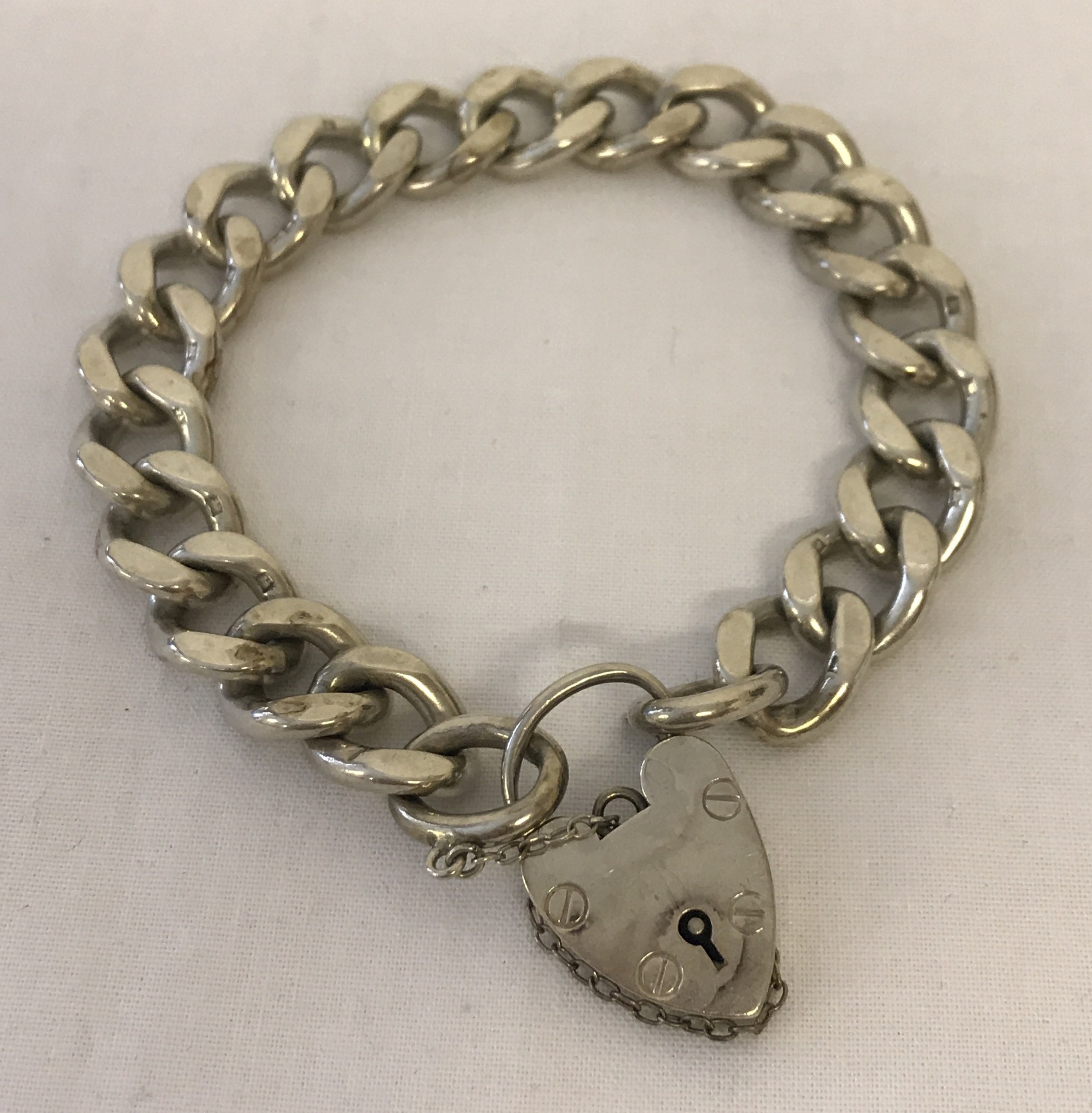 A heavy curb style bracelet with padlock and safety chain.