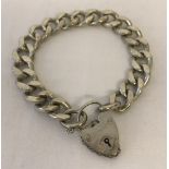 A heavy curb style bracelet with padlock and safety chain.