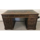 A Victorian Oak 9 drawer pedestal desk with leather insert to top and castor feet.