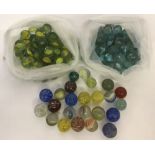 A collection of vintage marbles to include yellow, green and blue cats eye's, Swirlies and clearies.